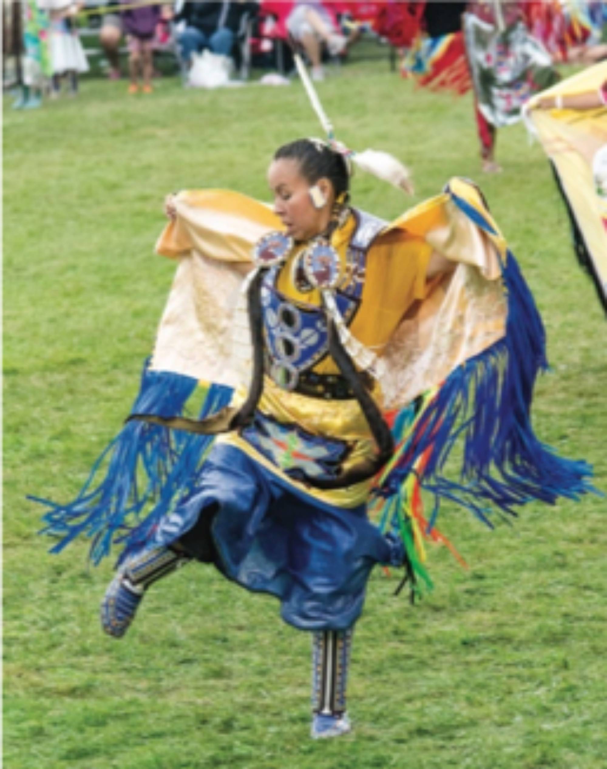 A woman wearing a shawl dancing at a Pow Wow